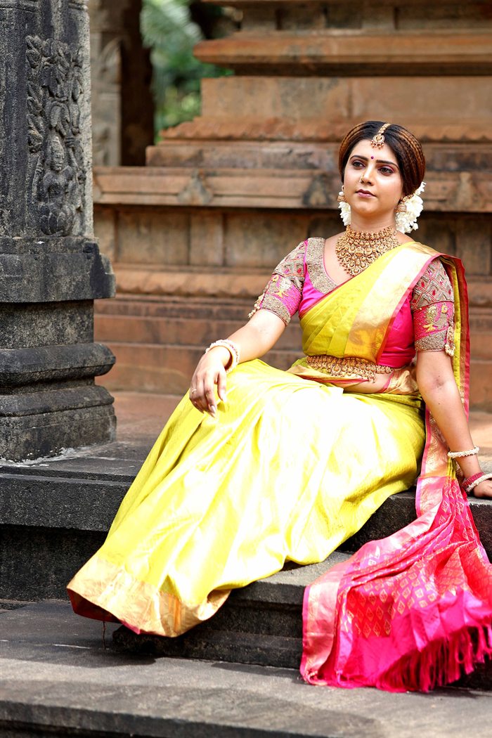 Bride sitting in yellow and gold silk saree at temple steps, Ashvi Beauty Care Jaffna