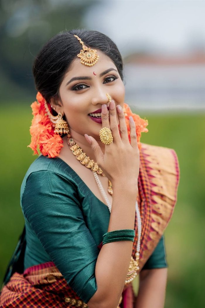 Candid smiling bride in green saree in a paddy field, Jaffna bridal makeup
